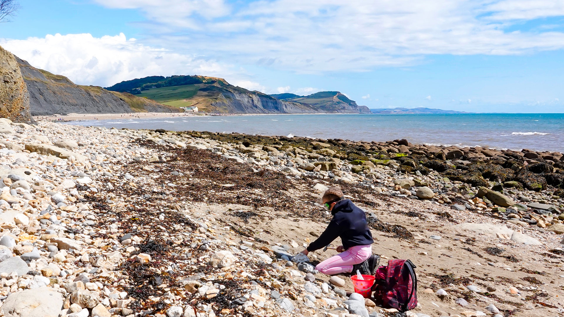 Woman fossil hunting on Charmouth beach