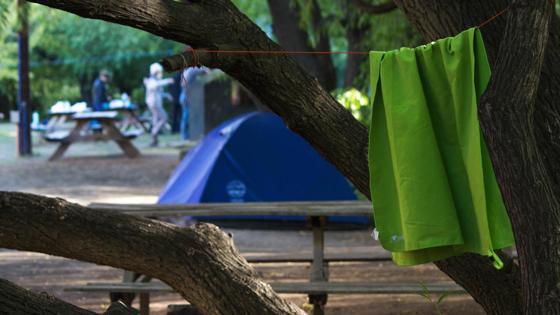 towel hanging between trees in a campsite