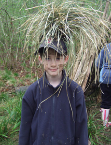 Learning to build a den is a great activity to enjoy when camping, as shown by a young Tom McGrath