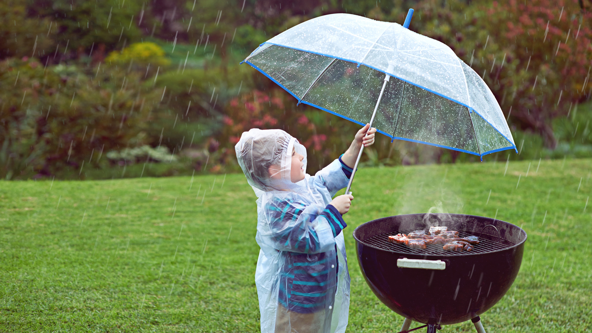 Child holding an umbrella at a BBQ