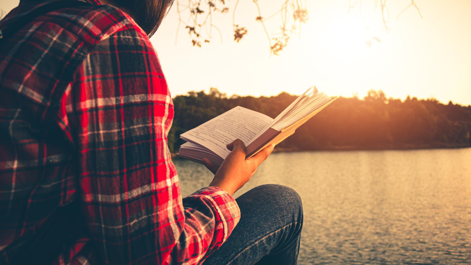 woman reading by a lake