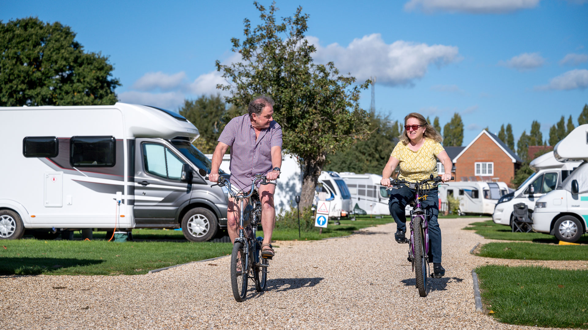 Couple cycling through campsite