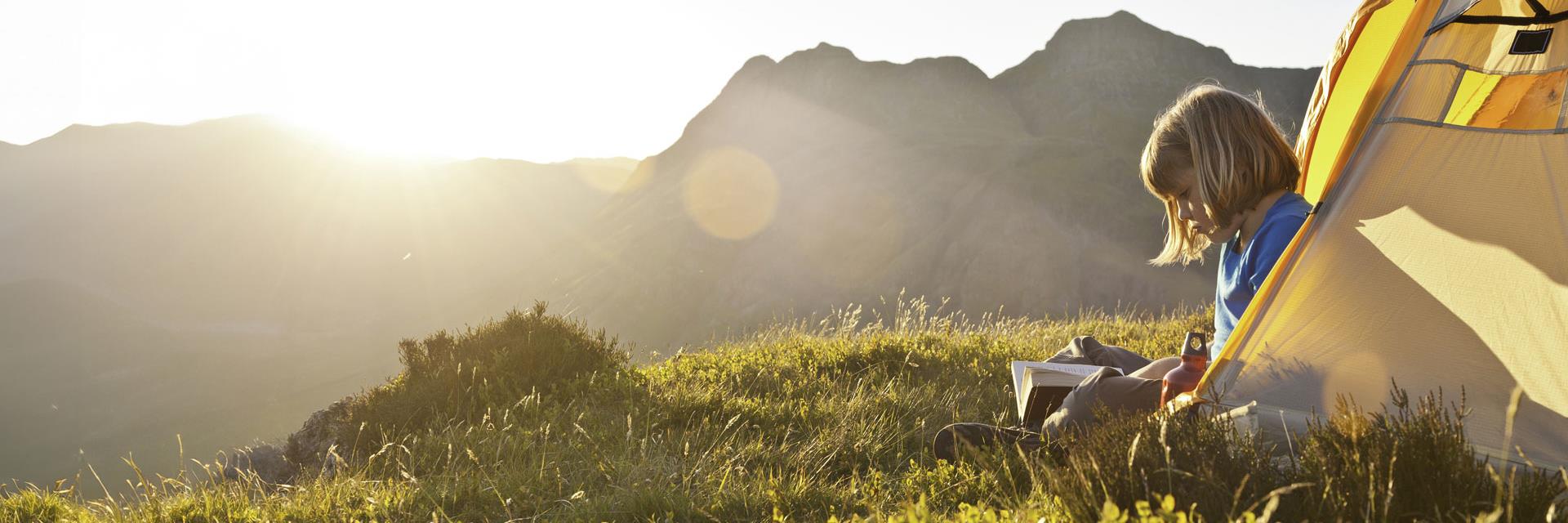 Girl reading book in tent