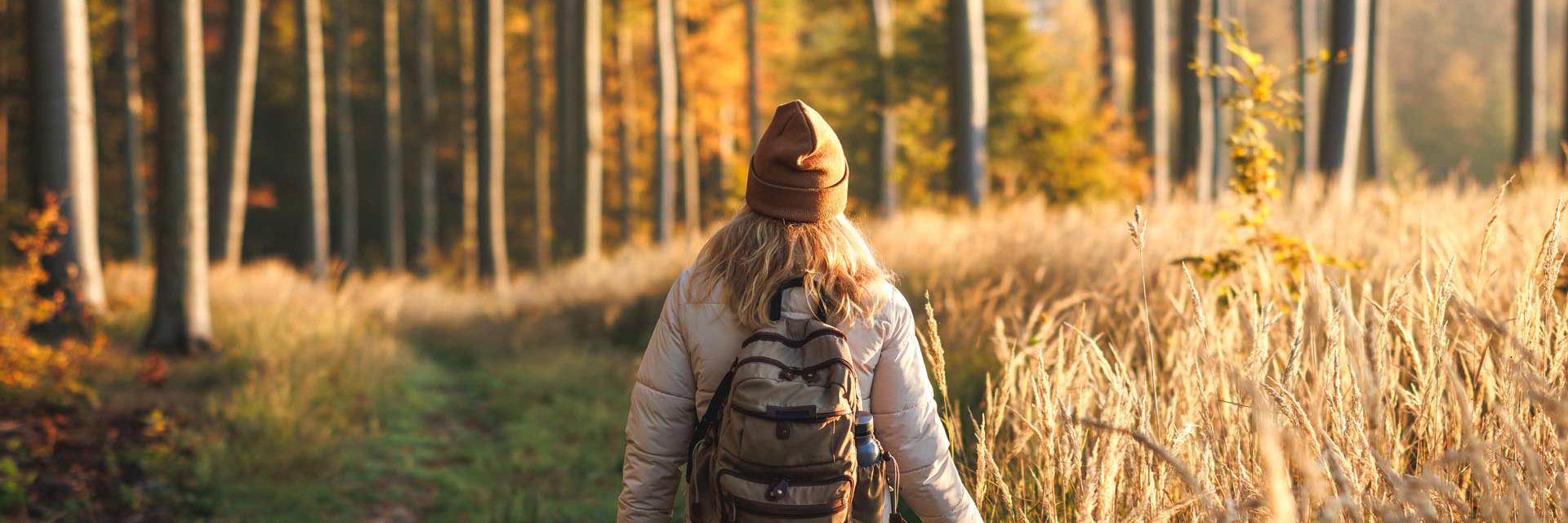 Girl walking through fields in autumn